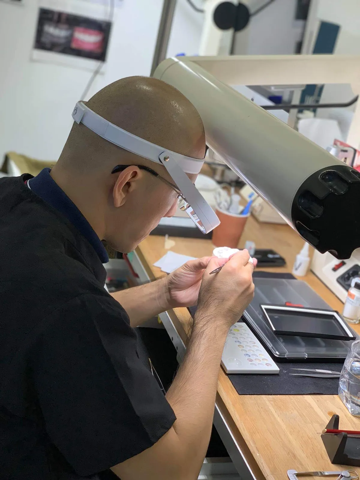 A DDA ceramist working under magnification at the laboratory bench